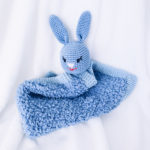 Un doudou super moelleux avec une tête de lapin crocheté et tricoté de couleur bleu.