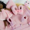 un kit naissance complet, une poupée et un doudou lapin. Une accroche tétine, une paire de chausson naissance et une paire de chausson 3/6 mois ainsi qu’une couverture l'ensemble de collection et en rose tendre layette.