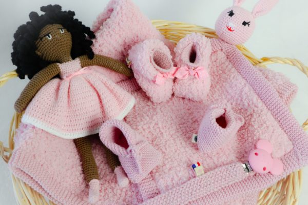 un kit naissance complet, une poupée et un doudou lapin. Une accroche tétine, une paire de chausson naissance et une paire de chausson 3/6 mois ainsi qu’une couverture l'ensemble de collection et en rose tendre layette.